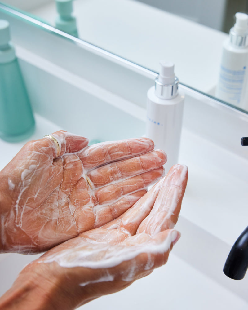 Lathered hands demonstrating gentle cleansing with Bio-Cleanse 5.5 Face wash in bathroom setting gallery position 1