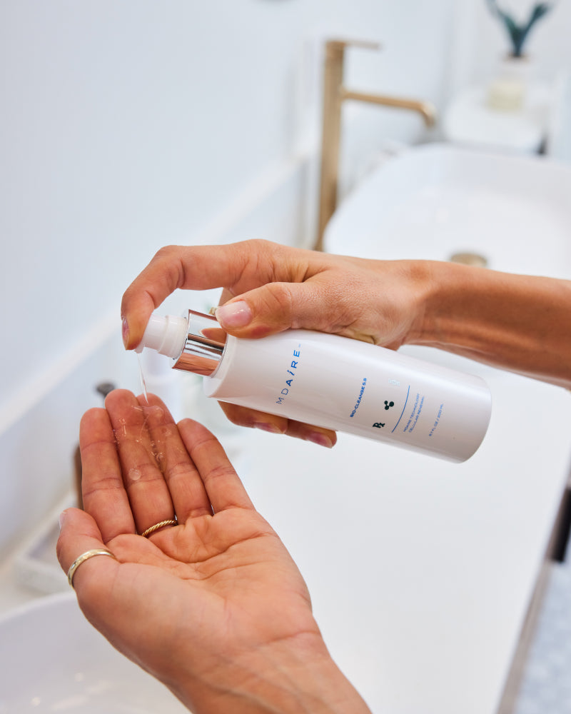 Fresh Start Duo hand dispensing cleanser with silver pump above open palm in gallery position 1 bathroom setting