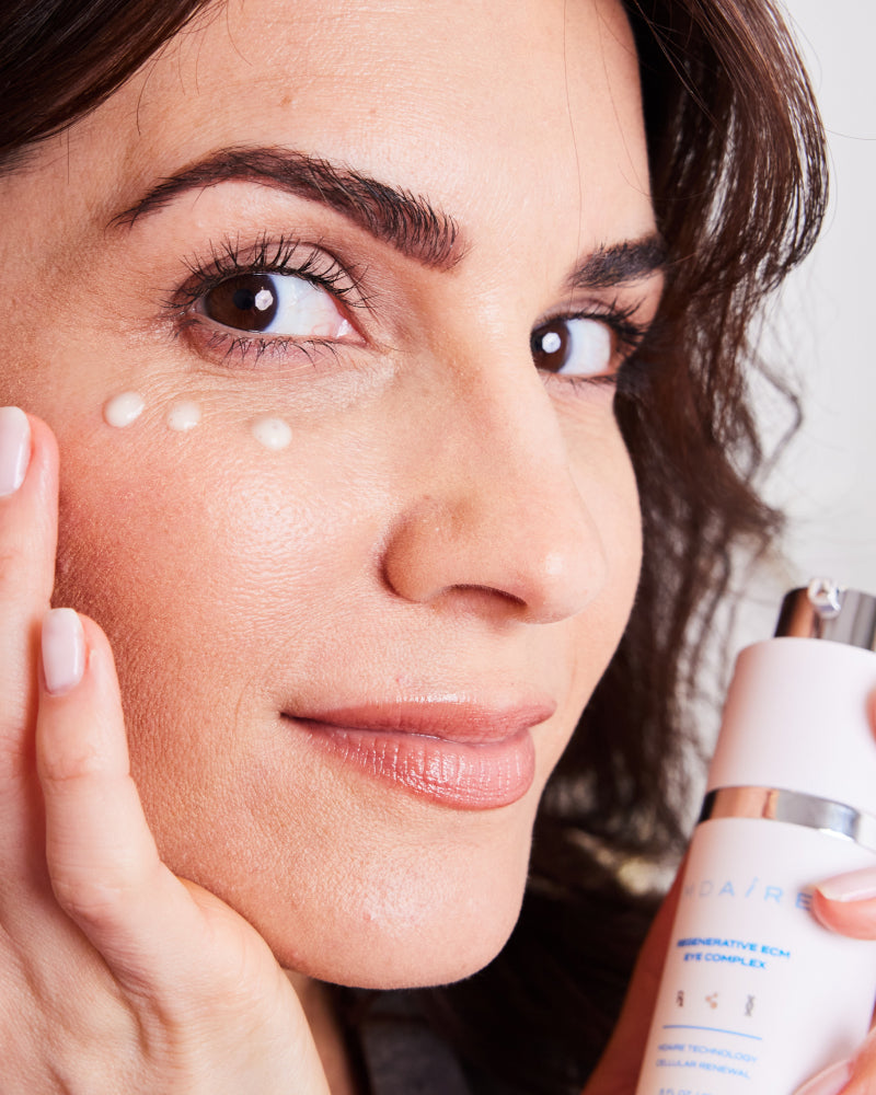 Woman applying MDAiRE 3-Step Glow Trio eye cream with gentle dots under the eye in gallery position 1