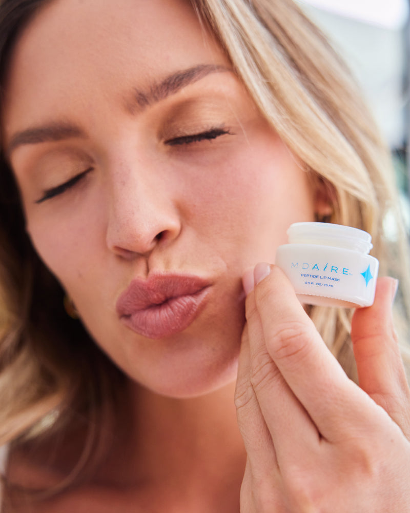 Get Started Bundle showing woman holding MDAiRE Peptide Lip Mask close to lips with eyes closed gallery 1