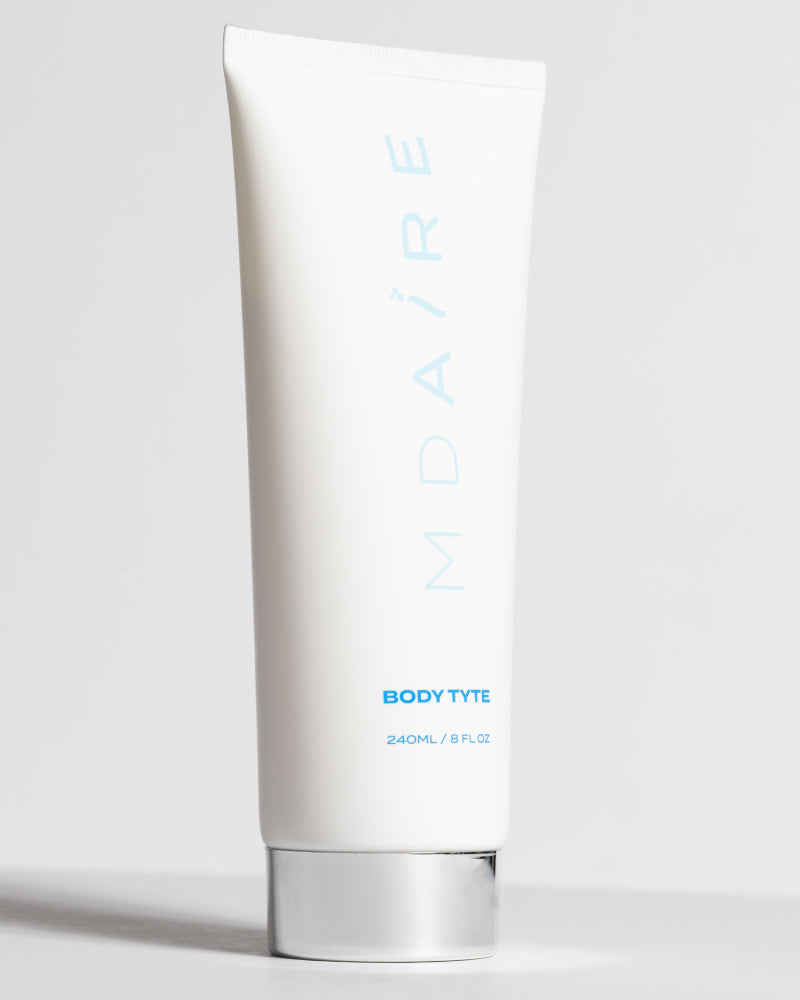 Body Glow Duo Body Tyte tube with silver cap standing upright on pale gray background gallery position 1
