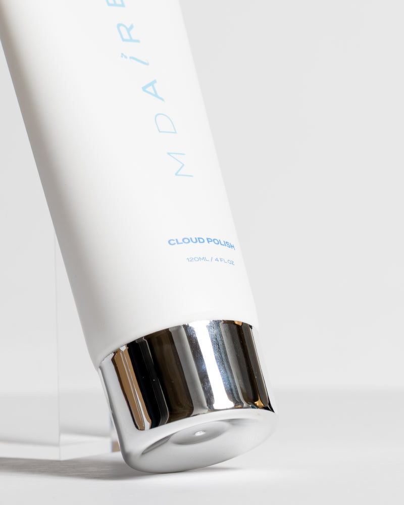 Close-up of Body Glow Duo Cloud Polish tube with reflective silver cap on pale gray background gallery position 1